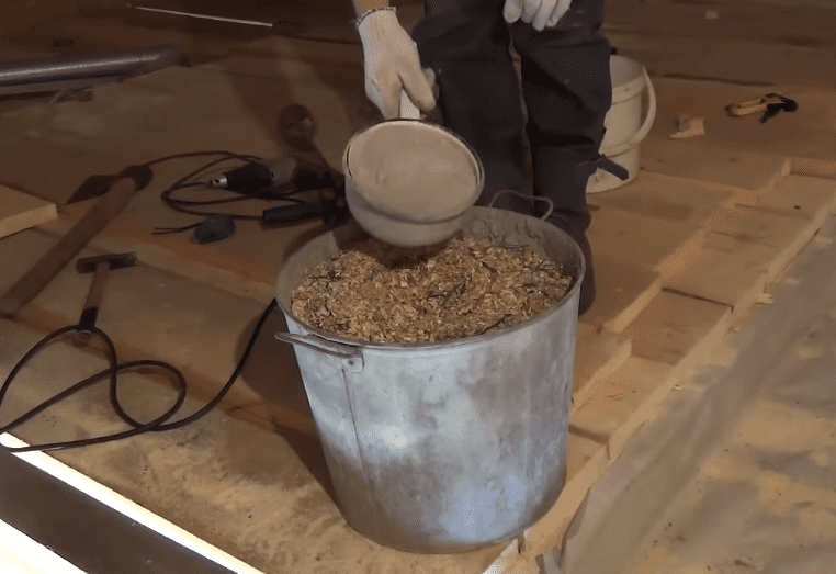 Замешивание опилок с цементом для создания утеплителя